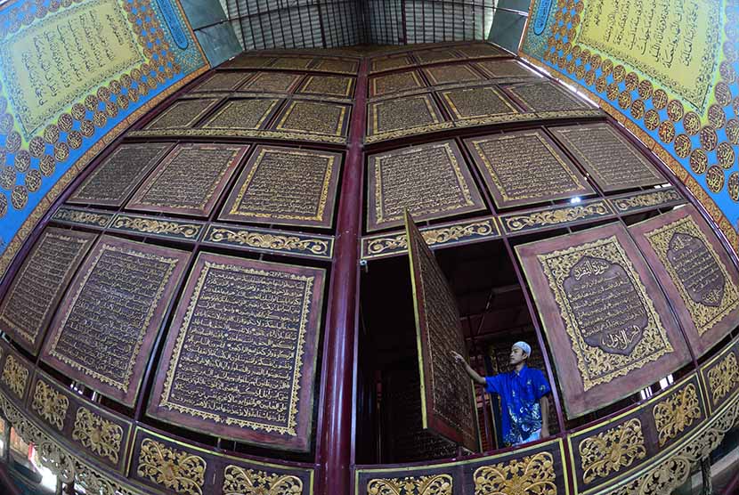 Seorang pengunjung mengisi hari pertama Ramadan dengan membaca Alquran raksasa di Gandus, Palembang, Sumsel, Kamis (18/6). (Anatar/Yahanan Sulam)