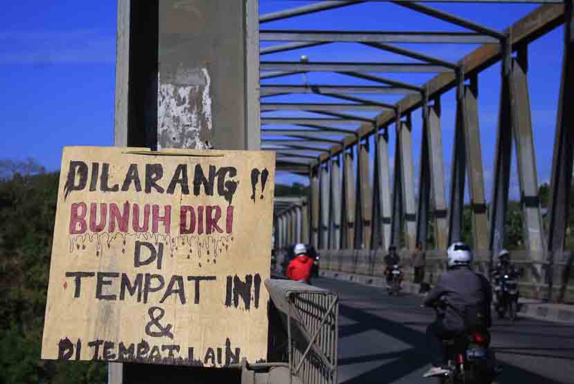 Sejumlah pengendara bermotor melintas di depan sebuah papan pemberitahuan yang dipasang di Jembatan Liliba Kupang, NTT, Sabtu (20/6).  