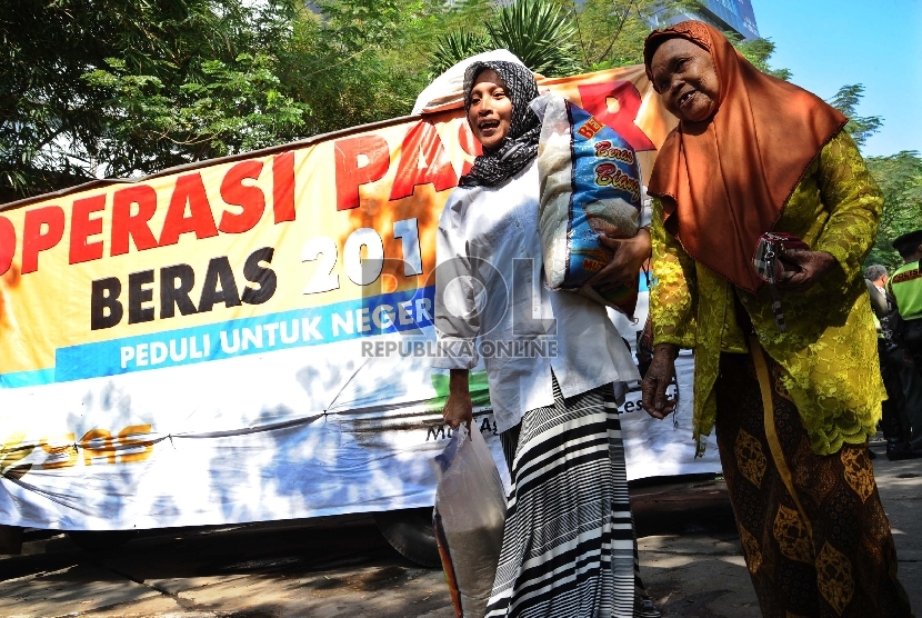 Warga membeli beras saat operasi pasar di Kantor Kemendag, Jakarta, Ahad (21/6). (Republika/Tahta Aidilla)