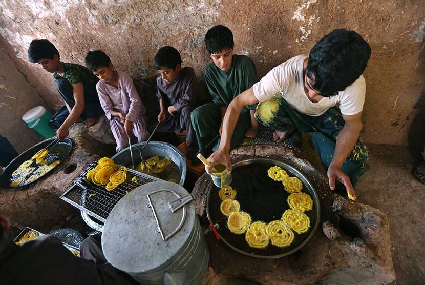  Anak-anak menyiapkan makanan kue tradisional Jalabi di kota Herat, Afghanistan.  (EPA/Jalil Rezayee)