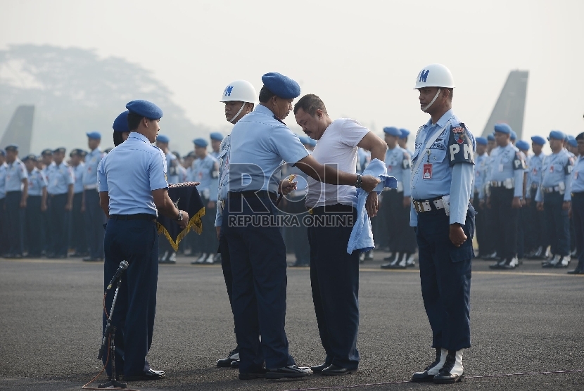 Komandan Lanud Halim Perdanakusuma Marsma TNI Umar Sugeng Hariyono mencopot atribut kedinasan Kopda Agung Hari Panilih (kedua kanan) dalam Upacara Militer Pemberhentian Tidak Dengan Hormat di Jakarta, Senin (29/6). (Republika/Raisan Al Farisi)