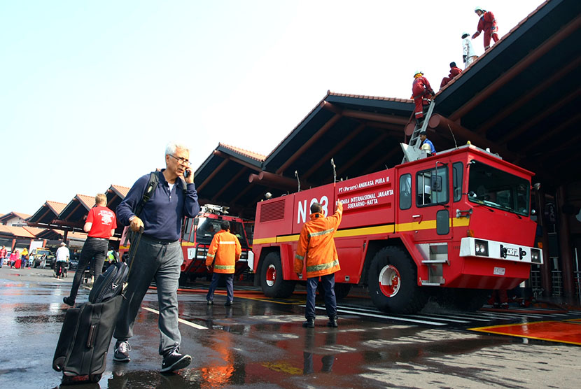  Petugas pemadam kebakaran melakukan pendinginan Gate 3 keberangkatan Luar Negeri yang terbakar di Terminal 2E Bandara Soekarno Hatta, Tangerang, Banten, Ahad (5/7). (Antara/Muhammad Iqbal)