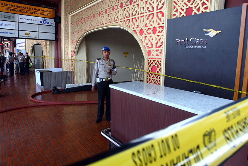  Petugas kepolisian berjaga pintu masuk Gate 3 keberangkatan Luar Negeri yang terbakar di Terminal 2E Bandara Soekarno Hatta, Tangerang, Banten, Ahad (5/7). (Antara/Muhammad Iqbal)
