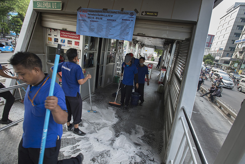 Pekerja membenahi halte transjakarta yang terbakar (ilustrasi).