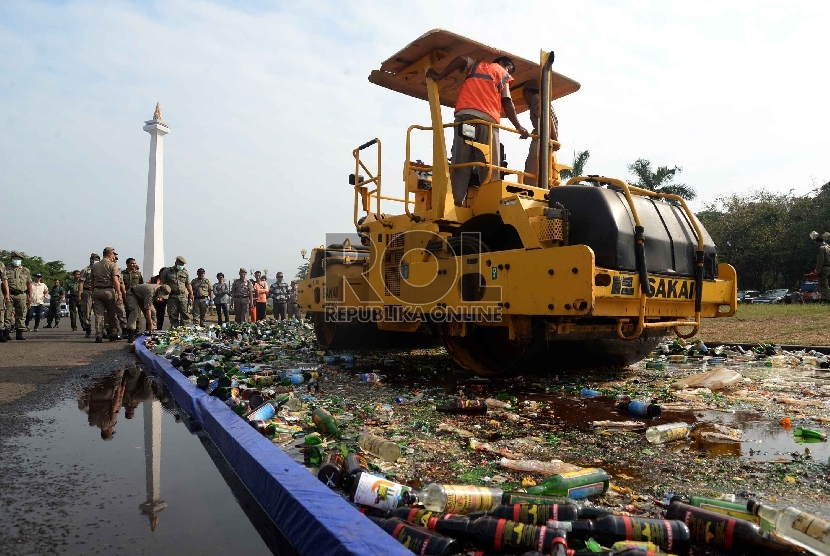 Alat berat memusnahkan ribuan botol minuman keras (miras) di Silang Monas, Jakarta, Selasa (7/7).  (Republika/Yasin Habibi)