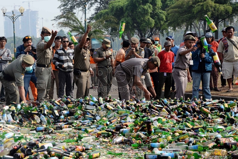  Petugas satpol PP memusnahkan ribuan botol minuman keras (miras) di Silang Monas, Jakarta, Selasa (7/7).   (Republika/Yasin Habibi)