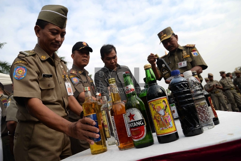  Petugas satpol PP memusnahkan ribuan botol minuman keras (miras) di Silang Monas, Jakarta, Selasa (7/7).   (Republika/Yasin Habibi)
