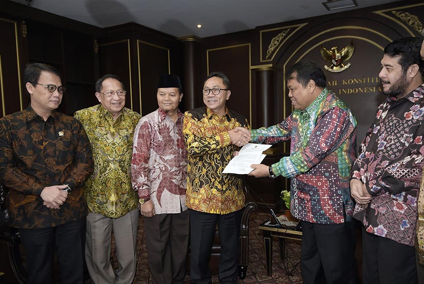 Ketua MPR Zulkifli Hasan (kiri) menyerahkan undangan pelaksanaan Sidang Tahunan MPR kepada Ketua Mahkamah Konstitusi (MK) Arief Hidayat (kanan) di Gedung MK, Jakarta, Kamis (9/7).  (Antara/Sigid Kurniawan)