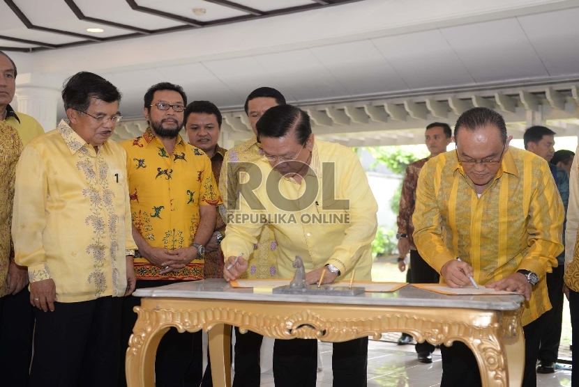 (dari kiri) Wakil Presiden RI Jusuf Kalla menyaksikan penandatanganan nota kesepahaman antara Ketua Umum Golkar Munas Ancol Agung Laksono dengan Ketua Umum Golkar Munas Bali Aburizal Bakrie saat pertemuan islah di Jakarta, Sabtu (11/7). (Republika/Wihdan)