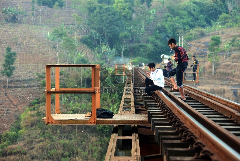 Sejumlah warga menikmati pemandangan Jalan Lingkar Nagreg sambil menanti saat berbuka puasa di jembatan Kereta Api Citiis, Bandung, Jawa Barat, Ahad (12/7).  (Republika/Rakhmawaty La'lang/) 