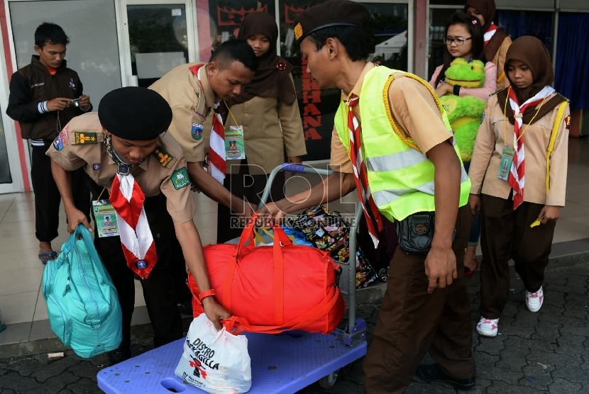  Anggota pramuka menolong membawakan barang bawaan pemudik di Pelabuhan Merak, Banten, Ahad (12/7).  (Republika/Prayogi)