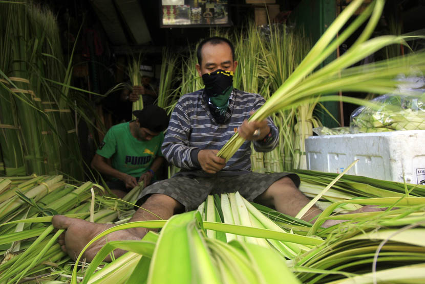 Penjual merapikan daun kelapa untuk dibuat kulit ketupat di Pasar Jatinegara, Jakarta Timur, Rabu (15/7).  (foto : MgROL_46)