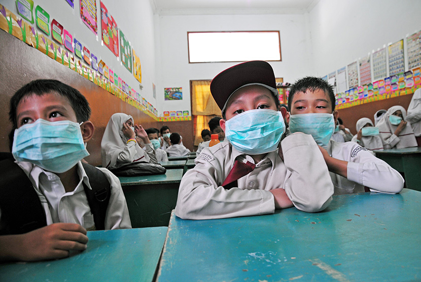    Sejumlah siswa SD Islam Terpadu Badan Pengelola Masjid An Nur terpaksa mengenakan masker di dalam kelas saat kabut asap menyelimuti Kota Pekanbaru, Riau, Senin (27/7).    (Antara/FB Anggoro)