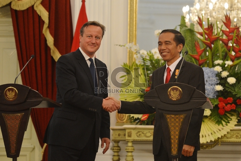 Presiden Joko Widodo (kanan) berjabat tangan dengan Perdana Menteri Inggris David Cameron (kiri) seusai melakukan pertemuan di Istana Merdeka, Jakarta, Senin (27/7).  (Republika/Edwin Dwi Putranto)