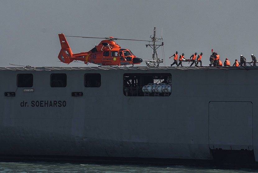  Helikopter Basarnas menurunkan prajurit TNI AL yang terluka ke KRI dr Soeharso-990  saat Simulasi Latihan Kesehatan Terpadu TNI AL di Dermaga Madura Ujung Koarmatim, Surabaya, Jawa Timur, Selasa (28/7).  (Antara//Zabur Karuru)