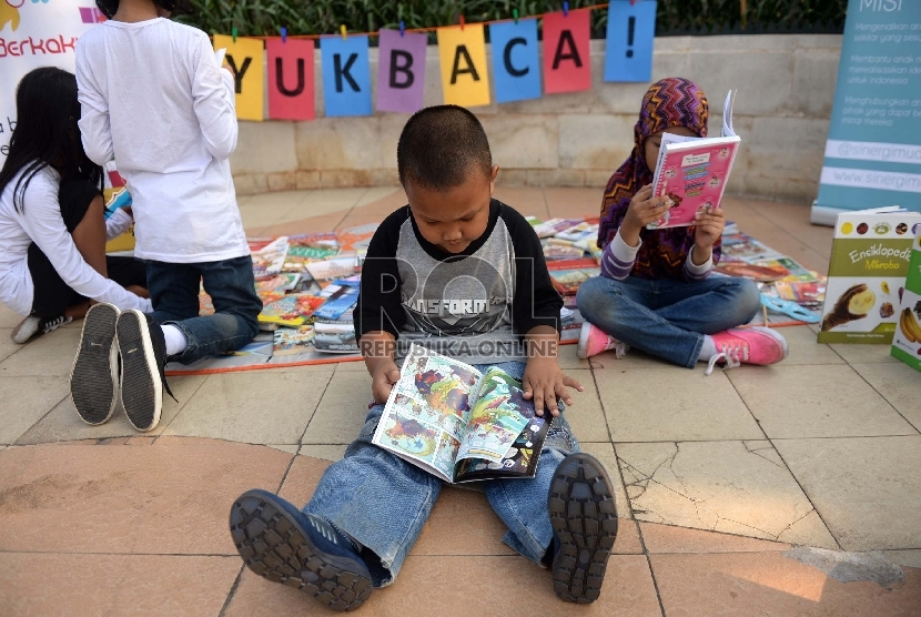 Sejumlah anak membaca buku pada rangkaian Peringatan Hari Anak Nasional (HAN) 2015 di Hari Bebas Kendaraan Bermotor, Jakarta, Ahad (2/8).   (Republika.WIhdan)