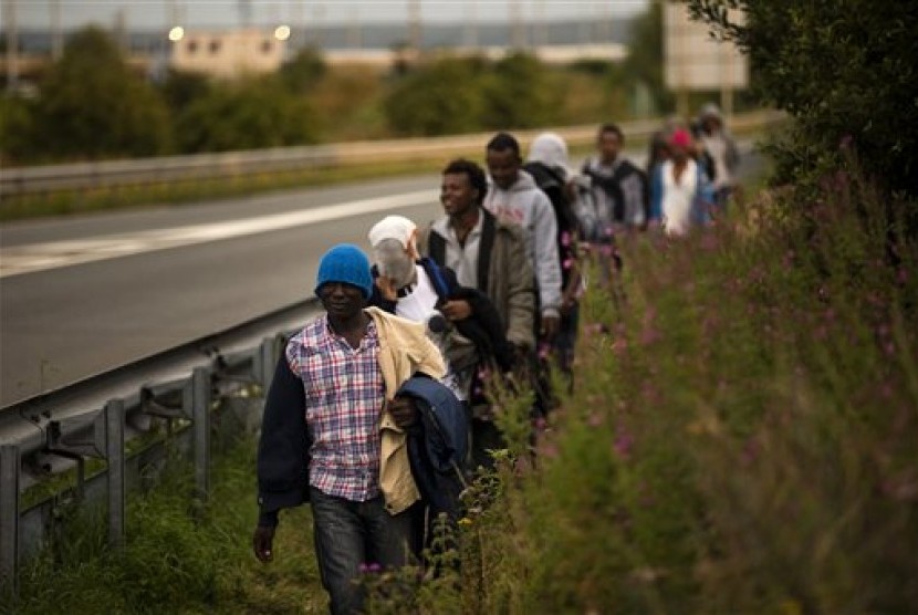  Ribuan migran berusaha menyeberang secara ilegal ke Inggris, di Prancis utara, Calais, Senin (3/8).  (AP/Emilio Morenatti)