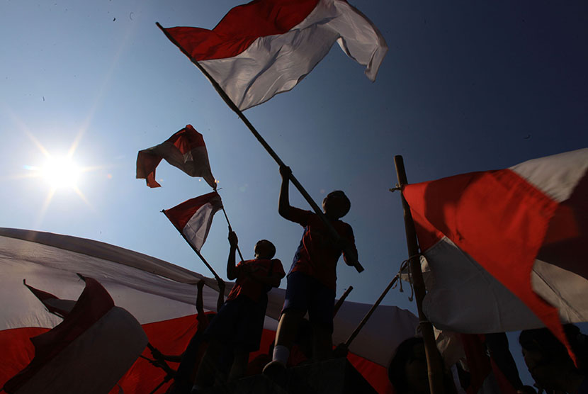 Siswa mengibarkan bendera merah putih pada acara Pesta Bendera di Monumen Mayor Achmadi, Banjarsari, Solo, Jawa Tengah, Selasa, (11/8). 