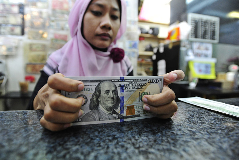 Seorang petugas menghitung pecahan dolar AS yang akan ditukarkan di salah satu gerai penukaran mata uang asing di Jakarta, Senin (24/8).  (Antara/Wahyu Putro A)