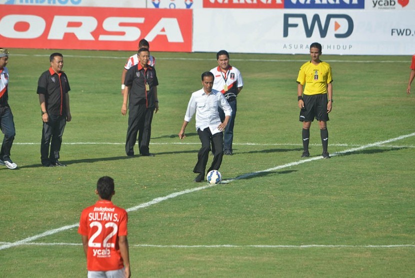 Presiden Joko Widodo menendang bola saat membuka pertandingan Piala Presiden di Stadion Dipta, Gianyar, Ahad (30/8). 