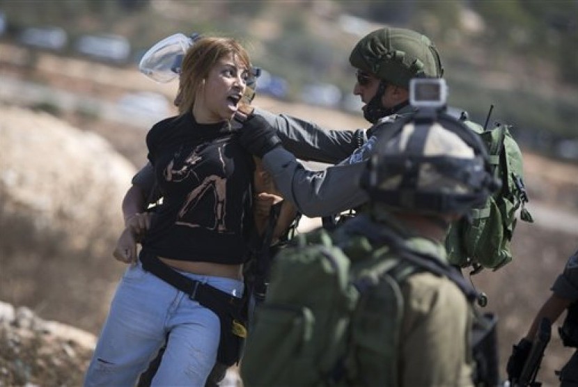 Tentara Israel menahan seorang wanita Palestina.