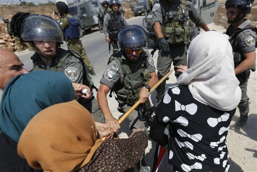 Tentara Israel menghalau pengunjuk rasa wanita Palestina.