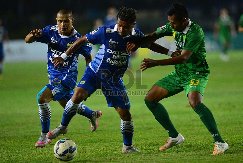  Pemain Persib Bandung, Zulham Zamrun berebut bola dengan Persebaya United, Munhar pada penyisihan grup A kompetisi Piala Presiden di stadion Si Jalak Harupat, Kota Bandung, Ahad (6/9) malam. (foto : Septianjar Muharam)