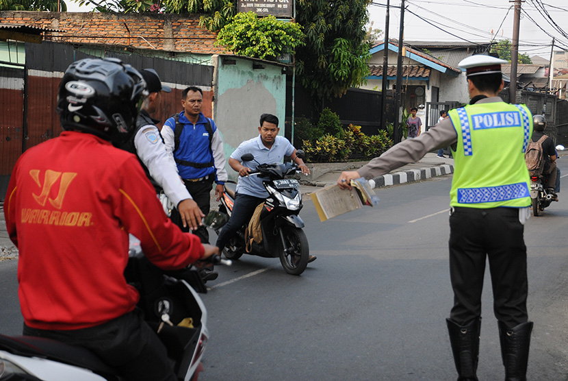 Petugas Ditlantas Polda Metro Jaya dibantu petugas Dishub Jakarta Selatan memberhentikan pengendara motor yang melawan arus saat razia di kawasan Tanjung Barat, Jakarta Selatan, Rabu (9/9).(Antara/Indrianto Eko Suwarso)
