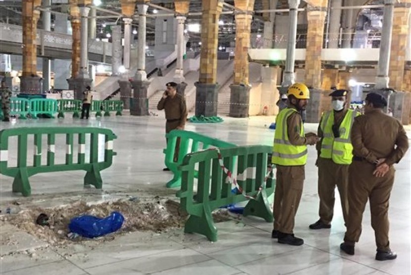 Petugas mengamankan lokasi jatuhnya crane di Masjidil Haram, Jumat (11/9).  (AP/Saudi Interior Ministry General Directorate of Civil Defense)
