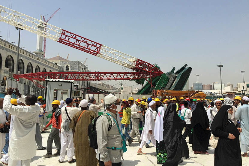 Sejumlah jamaah melintasi crane proyek perluasan masjid yang jatuh di Masjidil Haram, Makkah pada 12 September 2015. Insiden Crane Jatuh Masjidil Haram 2015, Saudi Binladin Group Didenda Rp 81 Miliar (Reuters/Mohamed Al Hwaity)      