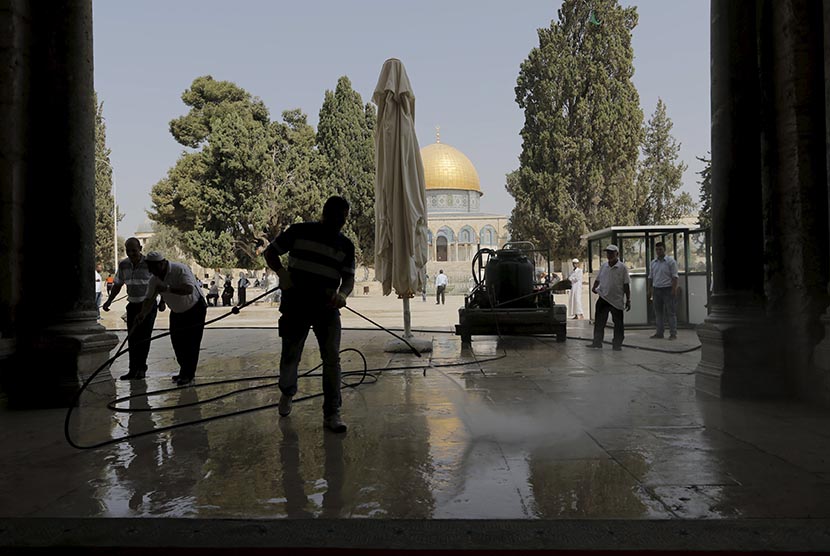 Warga Palestina membersihkan puing-puing akibat serangan polisi Israel ke komplek Masjid Al Aqsa di Yerusalem.