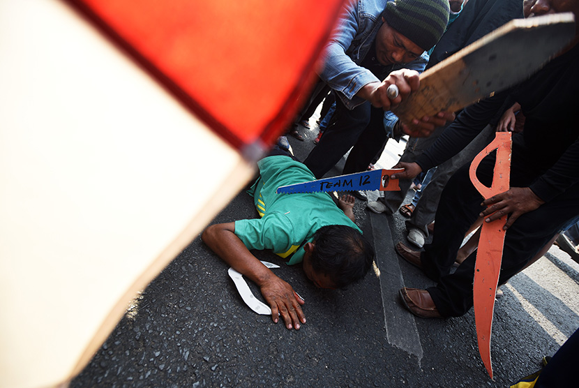 Warga yang tergabung dalam Solidaritas Aktivis Anti Kekerasan menggelar teatrikal penganiayaan dan pembunuhan aktivis lingkungan Salim 'Kancil' dan Tosan di Surabaya, Jawa Timur, Jumat (2/10).   (Antara/Zabur Karuru)