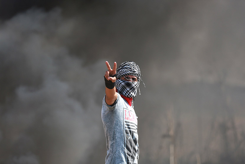  Ekspresi pemuda Palestina saat terlibat bentrok dengan pasukan pendudukan Israel di dekat perbatasan Gaza dengan Israel, Sabtu (10/10). (REUTERS/Yasser Gdeeh)