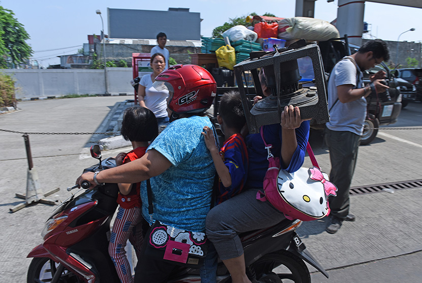  Warga yang rumahnya terdampak pengerjaan proyek sodetan Ciliwung - KBT mengangkut barang-barangnya dengan sepeda motor di daerah Bidara Cina, Jakarta, Ahad (11/10).   (Antara/Hafidz Mubarak)