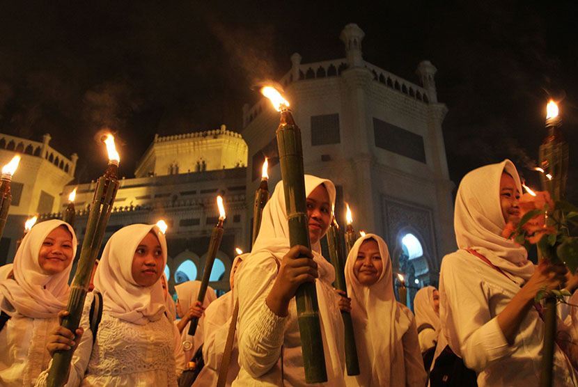 Umat Muslim memegang obor ketika mengikuti pawai dari Masjid Raya Al Mashun menuju Masjid Agung, Medan, Sumatera Utara, Selasa (13/10) malam.  (Antara/Irsan Mulyadi)