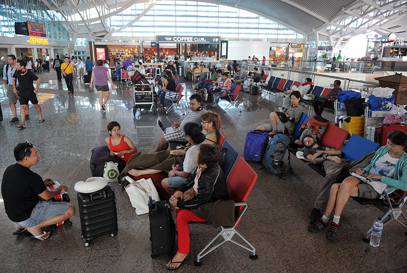 Petugas bandara memberi penjelasan kepada sejumlah warga negara asing saat mereka menunggu jadwal penerbangannya di Terminal Internasional Bandara Ngurah Rai, Denpasar, Rabu (4/11). (Antara/Nyoman Budhiana)
