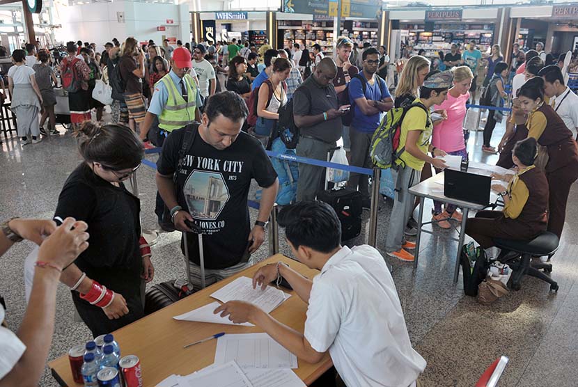 Sejumlah warga negara antre mendapatkan informasi penerbangannya di Terminal Internasional Bandara Ngurah Rai