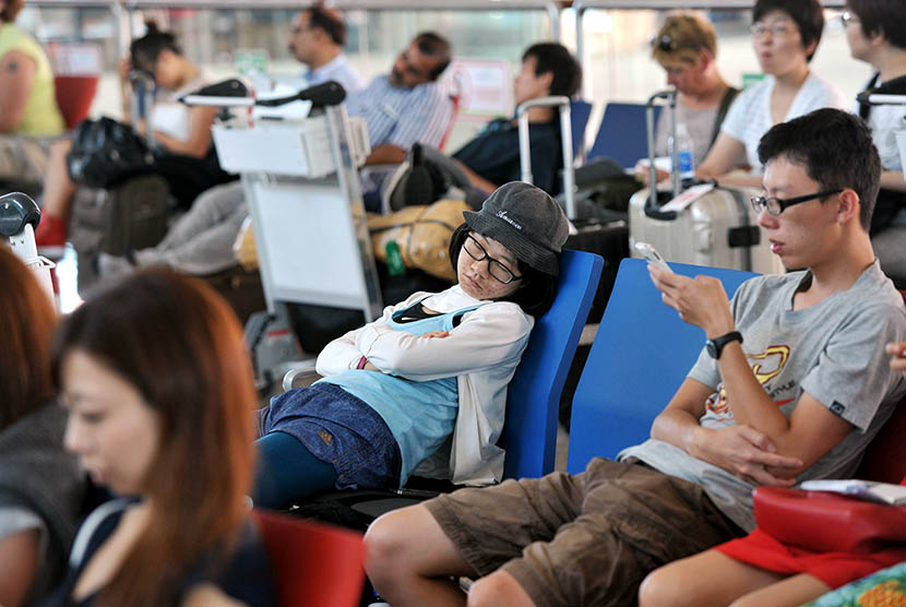 Sejumlah warga negara asing tertidur saat menunggu informasi penerbangannya di Terminal Internasional Bandara Ngurah Rai, Denpasar, Kamis (5/11).   (Antara/Nyoman Budhiana)