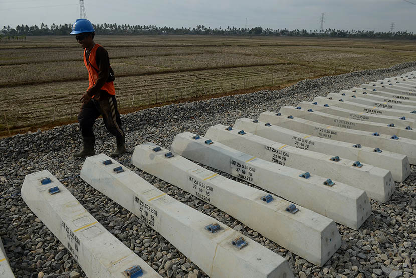 Pekerja melintasi bantalan jalur kereta api trans Sulawesi di Pekkae, Barru, Sulawesi Selatan. Pembangunan rel kereta penghubung Makassar-Parepare, Sulsel segera diselesaikan.
