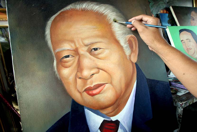 Seroang pelukis melukis wajah presiden kedua RI Soeharto.