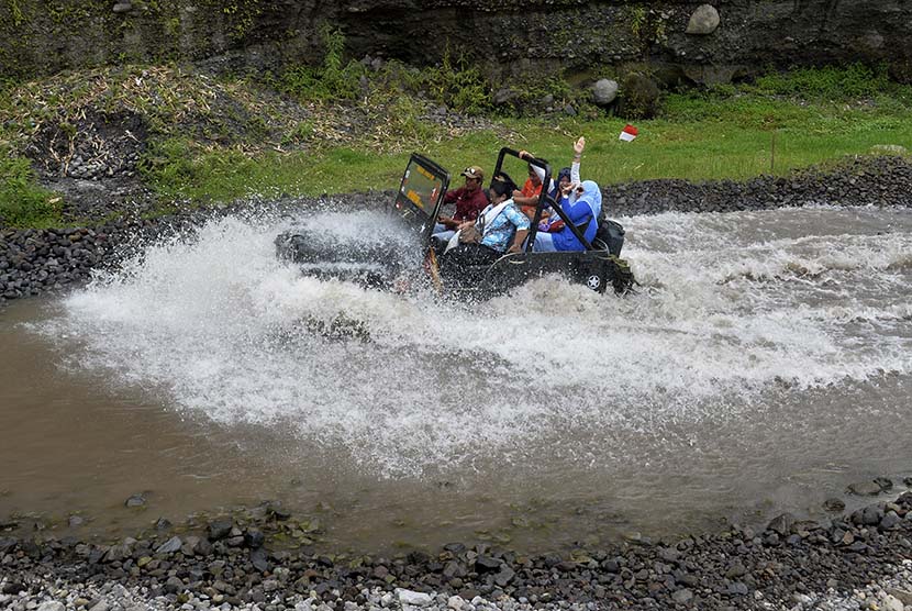 Sejumlah wisatawan menggunakan mobil jip melintasi anak sungai pada reli wisata di kawasan Gunung Merapi, Yogyakarta, Kamis (12/11).  (Antara/Saptono)