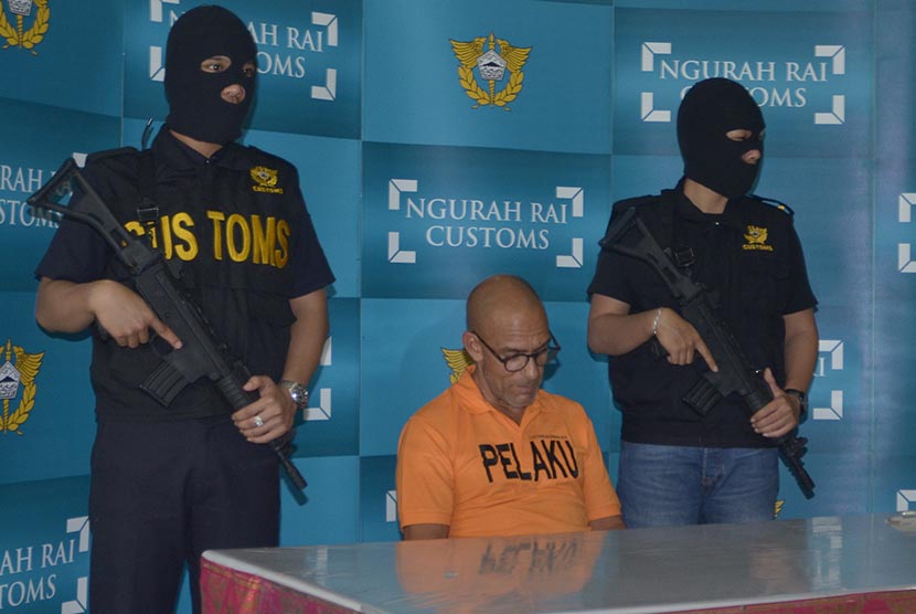 Petugas bea cukai mengawal tersangka warga Swiss Marc Andre Wenger (tengah) saat pengungkapan kasus penyelundupan narkoba di Kantor Bea Cukai Bandara Ngurah Rai, Denpasar, Kamis (12/11). 