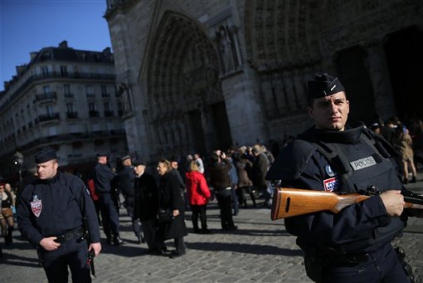  Polisi Prancis berjaga di Kota Paris, Ahad (15/11).  (AP/Christophe Ena)  