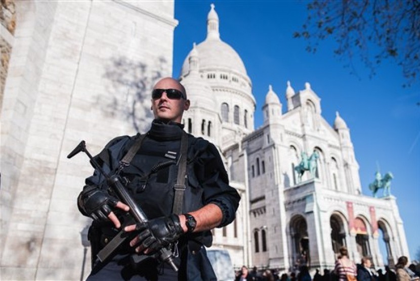  Polisi Prancis berjaga di depan Sacre Coeur Basilica, Paris, Ahad (15/11).  (AP/Kamil Zihnioglu)  