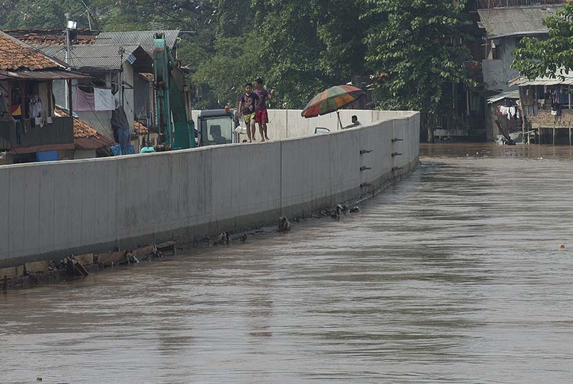 Dua orang bocah berjalan di atas turap di kawasan proyek normalisasi Sungai Ciliwung, Kampung Pulo, Jatinegara, Jakarta Timur, Rabu (25/11). (Antara/Widodo S. Jusuf)