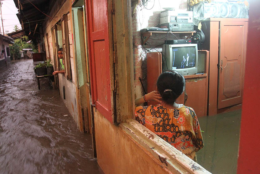  Seorang warga menonton televisi didalam rumahnya saat banjir yang melanda di daerah Keluarahan Pulai Anak Aia, Kecamatan Mandiangin Koto Selayang, Bukittinggi, Sumatera Barat, Jumat (27/11). (Antara//Muhammad Arif Pribadi)