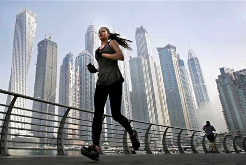  Seorang wanita lari pagi di depan gedung pencakar langit di kawasan Marina Dubai.  (AP/Kamran Jebreili)