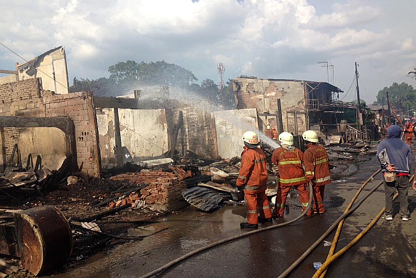  Petugas pemadam kebakaran memadamkan api kebakaran yang terjadi di Jalan Bukit Duri Pangkalan, Kecamatan Tebet, Jakarta Selatan, Kamis (24/12). 