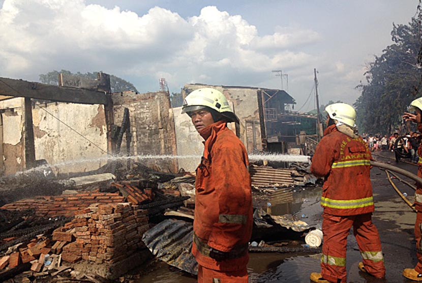  Petugas pemadam kebakaran memadamkan api kebakaran yang terjadi di jalan Bukit Duri Pangkalan, Tebet, Jakarta Selatan, Kamis (24/12).  (Republika/Maman Sudiaman)