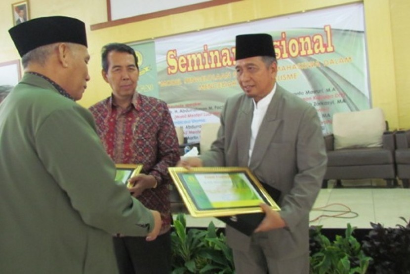 Dr Martin Roestamy, Rektor Unida Bogor menyerahkan piagam penghargaan pada Dr Ahmad Hidayatullah Zarkasyi dari Gontor